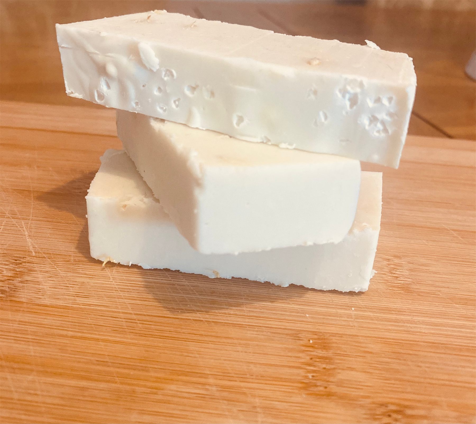 Freshly cut bars of handmade natural soap on a wooden board