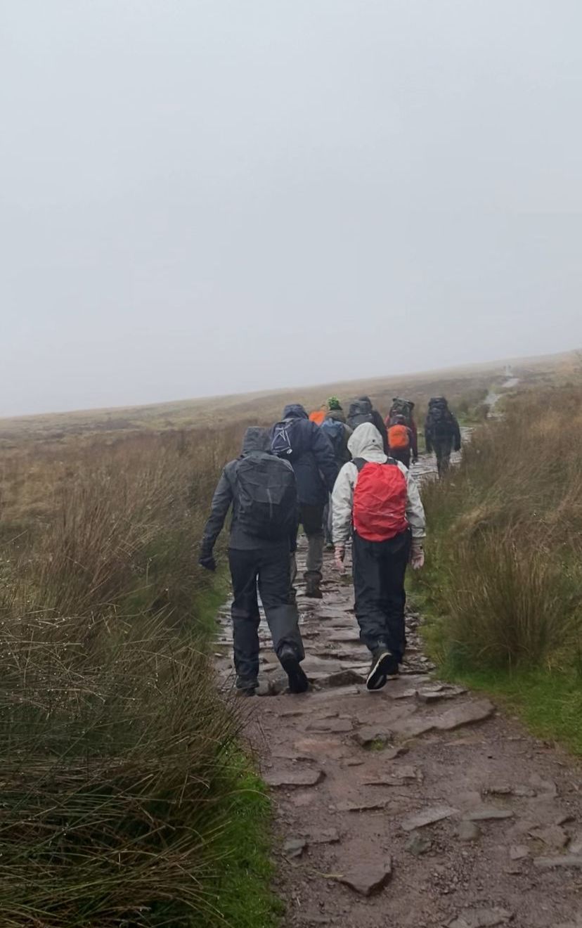 Walkers on a misty hillside path in the Brecon Beacons